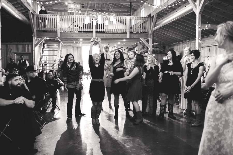 Young Woman Catching Bouquet at Barn Wedding